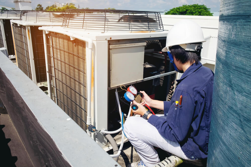 HVAC technician checking rooftop commercial AC unit