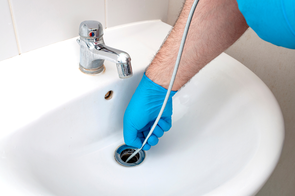 Clearing a pipe blockage with a drain snake